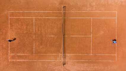 View from above, aerial view of two people playing tennis on a clay court - obrazy, fototapety, plakaty