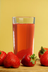 Fresh delicious strawberry juice pours into a glass. Healthy antioxidant juice with vitamin from ripe fruits. Vertical photo