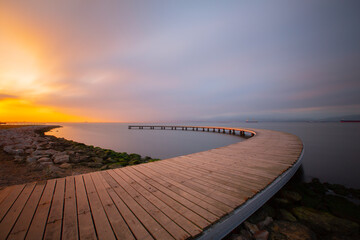 The pier like a boomerang at sunrise was captured with the long exposure technique.