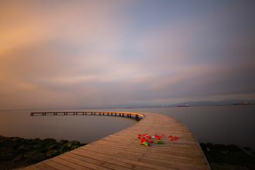 The pier like a boomerang at sunrise was captured with the long exposure technique.