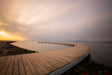 The pier like a boomerang at sunrise was captured with the long exposure technique.