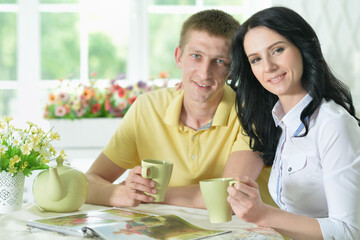 Portrait of young couple reading interesting book