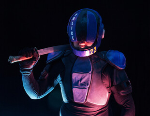 Cyberpunk future concept. Bionic cyborg police officer with short samurai sword stands in dark....