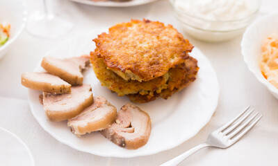 Potato pancakes with meat on white plate