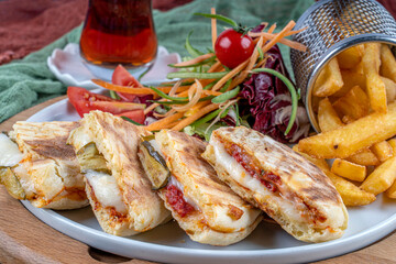 Bazlama Toast,Turkish toast flat baked bread called bazlama with Turkish sausage and cheese served with fried patatoes,salad and a glass of tea