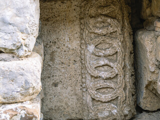 Background of the masonry of an ancient temple. Place of religious ceremonies. An ancient stone wall with images that have undergone devastating erosion.