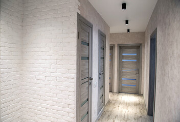 Modern corridor in an apartment after renovation in gray tones. Gray interior doors and black LED...