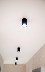 Beautiful black LED lights on the ceiling. Modern stretch ceiling design with lighting. New technologies, illumination