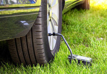Car wheel pumping with a car compressor. Tire puncture, close-up, background