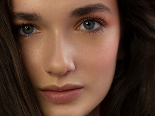 Fototapeta premium Close-up beauty woman with clean shiny skin and natural cosmetics. Fashion, spa, cosmetology, lip injections, eyeshadow on brown eyes and thick eyebrows, cosmetics, make-up, beautiful