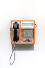 orange public telephone on white background