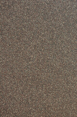 The texture of the surface of the wall sprayed with small pebbles.