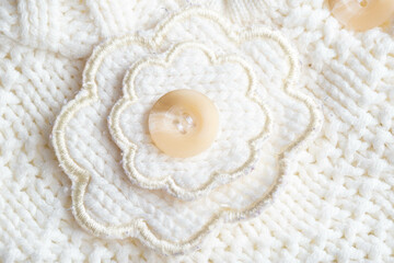 Comfortable warm knitted sweater made of white threads, background. Macro