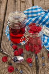 Jar of raspberries and spoon on table