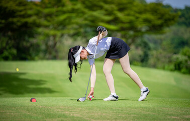 Professional woman golfer teeing golf in golf tournament competition at golf course for winner