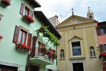 Old Church and Decorative Flowers on Balconies in Old Italian Village 