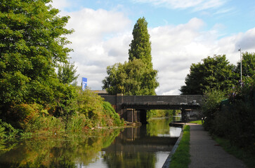 View Along Tree Lined Canal and Towpath against Blue Sky