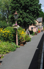Vintage Lamppost and Colourful Flowers on Platform of Rural Railway Station on Sunny Day 