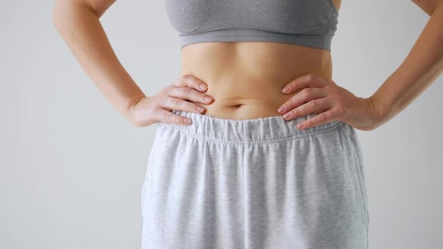 Woman puts on her pants. Concept of healthy digestion.