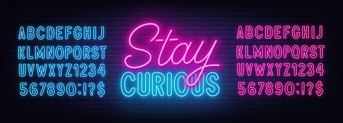Stay Curious neon lettering on brick wall background.