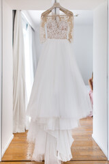Wedding dress hanging on the door in the white room