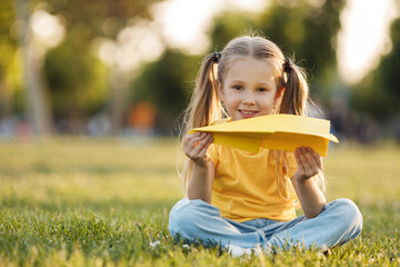 little cute girl with paper airplane outdoor