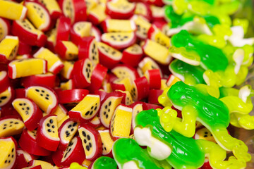 Candy sweets jelly. Close up view of delicious sweet candies in form of passion fruits, frogs. Fruit jelly in shop window. Sweets for Easter, Halloween. Unhealthy or organic food. Selective focus