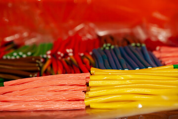 Candy jelly sweets. Close up view of delicious sweet candies in form of sticks. Fruit jelly in shop window. Sweets for Easter, Halloween, candy for sale. Unhealthy or organic food. Selective focus 