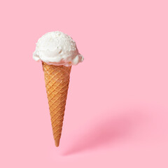 summer funny creative concept of flying wafer cone with scoop of ice cream on pink background