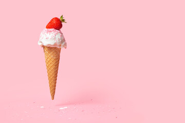 summer funny creative concept of flying wafer cone with ice cream, strewed sprinkles and decorated strawberry on pink background