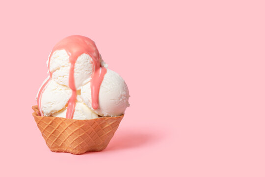 summer funny creative concept of cone with scoops of ice cream poured with icing on pink background, copy space
