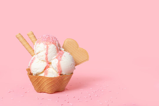 cone with scoops of ice cream strewed sprinkles and poured with glaze on pink background