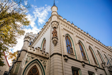 Obraz premium Riga, Latvia, 14 October 2021: Small Guild of St. John, Baltic states, Northern Gothic Style with arched windows and stone carvings, Facade of medieval buildings at sunny day, historic center