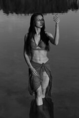 Young long-haired woman in bikini in the lake in black and white