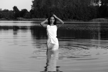 Young woman in dress in water in black and white