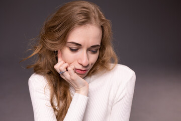 Portrait of thoughtful, dissatisfied, pensive young woman. Blong girl face isolated. Emotional woman immersed in your thoughts