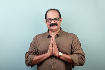 Portrait of a middle aged man of Indian ethnicity shows 'Namaskar' gesture
