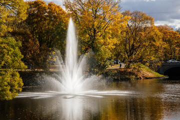 Riga, Latvia, 14 October 2021: Beautiful Bastejkalna Central Park with canals near the Latvian National Opera at autumn sunny day, bridge over water