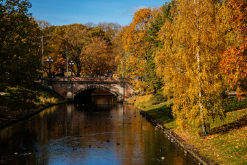 Riga, Latvia, 14 October 2021: Beautiful Bastejkalna Central Park with canals near the Latvian National Opera at autumn sunny day, bridge over water
