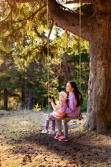 mother and child on a swing in the park