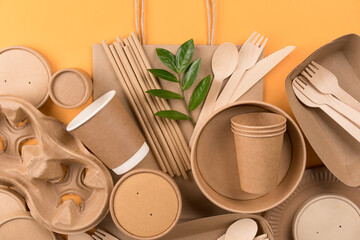Eco-friendly paper utensils - kraft paper food packaging on orange background. Street food paper...