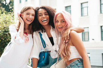 Fototapeta Three young beautiful smiling hipster female in trendy summer clothes.Sexy carefree multiracial women posing on the street background.Positive models having fun obraz