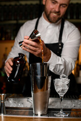 close-up view of shaker cups on bar counters in which the bartender pours a drink