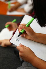 Close up of a childs hand practicing handwriting in school