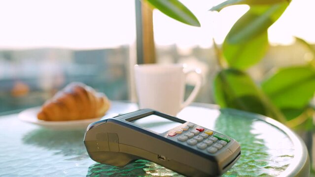 Contactless payment with smartphone. Wireless payment concept. Close-up, woman using smartphone cashless wallet NFC technology to pay order on bank terminal in a cafe.