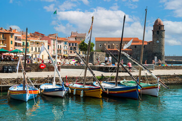 view on colorful sailing boats front of the famous tower of the france french city of collioure - obrazy, fototapety, plakaty