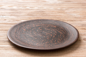 Perspective view of empty plate on wooden background. Empty space for your design