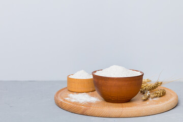 Flat lay of Wheat flour in wooden bowl with wheat spikelets on colored background. world wheat crisis