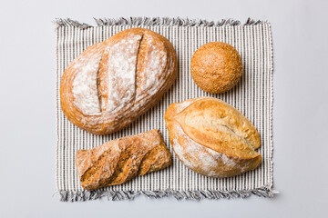 Assortment of freshly baked bread with napkin on rustic table top view. Healthy unleavened bread. French bread