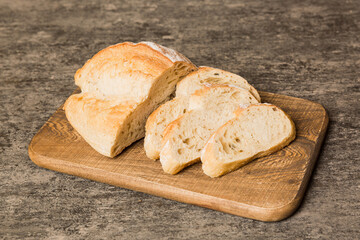 Assortment of freshly sliced baked bread with napkin on rustic table top view. Healthy unleavened bread. French bread slice